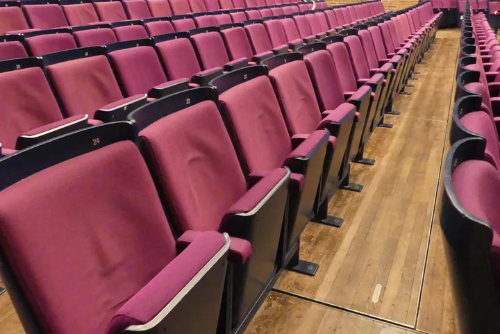 Theater-/Saalbestuhlung, 1 Reihe à 24 Sitzplätze, gepolsterte Klappsitze, pink/schwarz